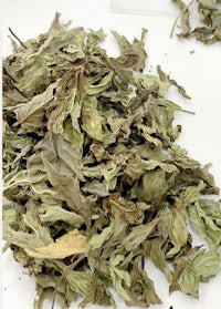 a pile of dried leaves on a white plate