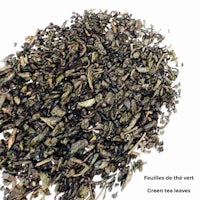 a pile of green tea leaves on a white background