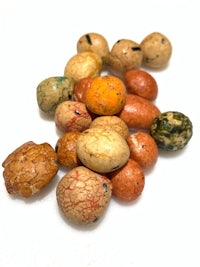 a pile of different colored beans on a white surface