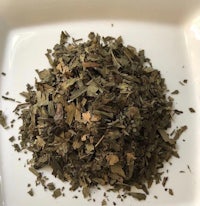 a pile of dried leaves on a white plate