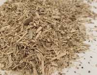 a pile of dried herbs on a white surface