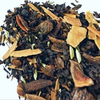 a pile of black tea on a white surface