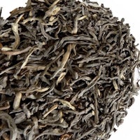 a pile of black tea on a white background