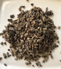 a pile of dried herbs on a white plate