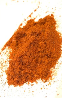 a pile of red powder on a white surface