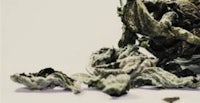 a bowl of dried marijuana on a white surface