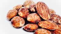 a pile of almonds on a white background