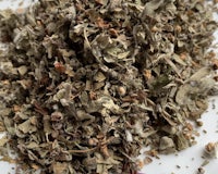 a pile of dried herbs on a white surface