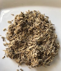 a pile of dried herbs on a white plate