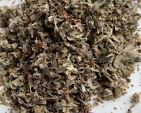 a pile of dried herbs on a white surface