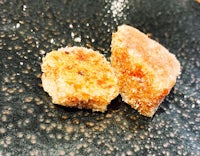 two pieces of sugar on a black plate