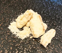 a pile of white powder on a black surface