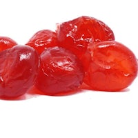 a pile of red cherries on a white surface