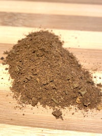 a pile of brown powder on a wooden table