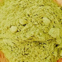 matcha powder in a bowl on a wooden surface