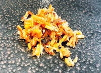 a pile of dried oranges on a black surface