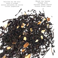 a pile of black tea with orange peels on top