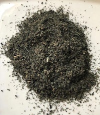a pile of green tea on a white plate