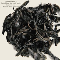 a pile of black tea leaves on a white background