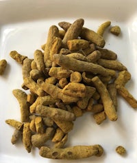 a pile of tumeric on a white plate