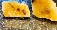 two pieces of orange peel sitting on top of a black surface
