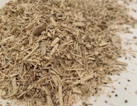 a pile of dried herbs on a white surface