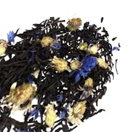 a pile of black tea with blue flowers on top