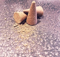 three incense cones sitting on a black surface